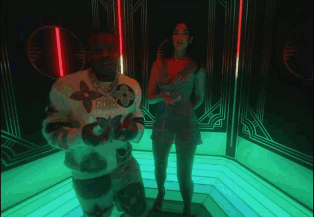 a man in a louis vuitton sweater stands next to a woman