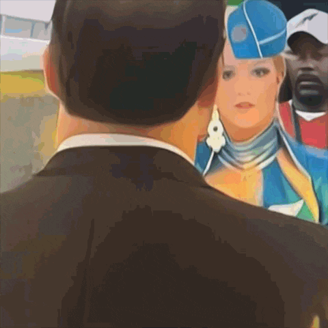 a man in a suit and a woman in a blue hat are standing next to each other
