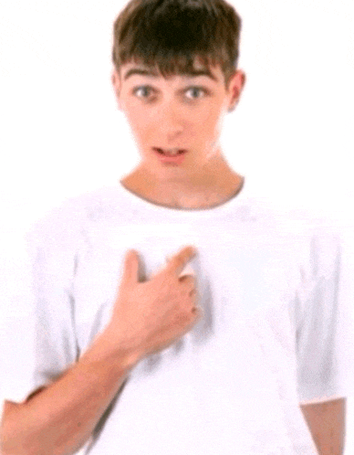 a young man in a white t-shirt is pointing to his chest