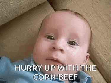 a baby is laying on the floor with the words `` hurry up with the corn beef '' written on his face .