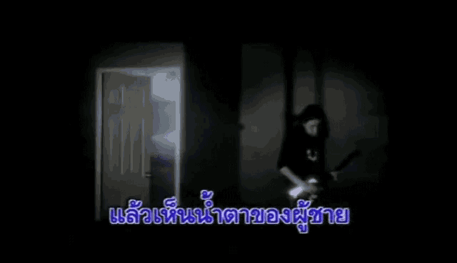 a woman is standing in a dark room holding a knife in her hand .