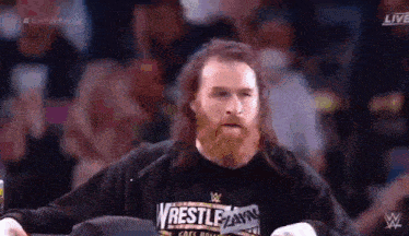 a man with a beard is wearing a t-shirt that says wrestlemania on it .