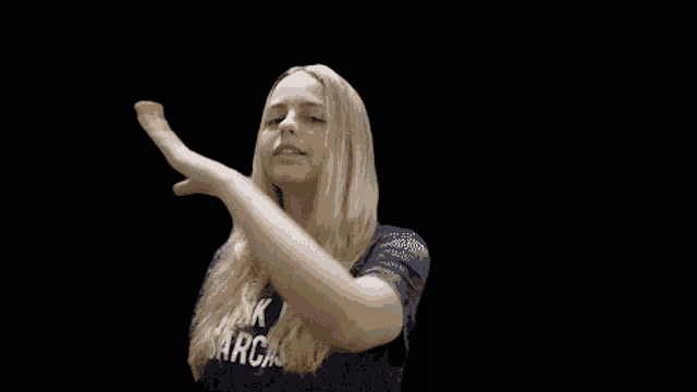 a woman in a black shirt with the word sarcasm on it is making a funny face .