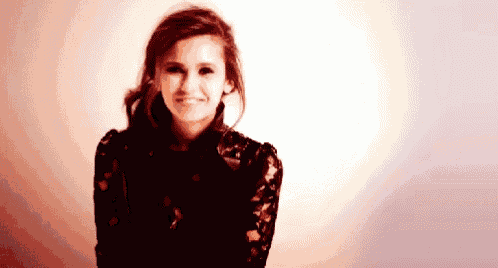 a woman in a black dress is smiling and looking at the camera