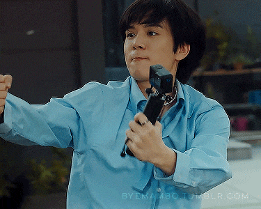 a man in a blue shirt is holding a microphone in his hands