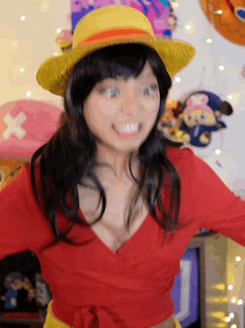 a woman wearing a red shirt and a yellow hat with a cross on it