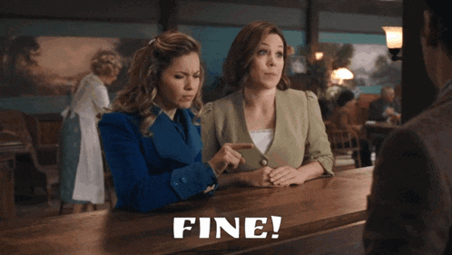 two women sitting at a counter with the word fine written on the top