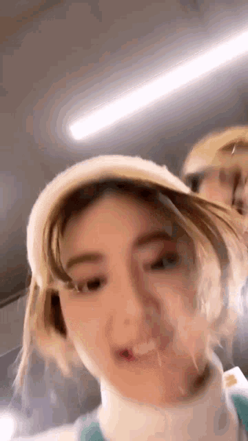 a woman wearing a hat and a turtleneck is making a funny face .
