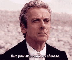 a man in a suit and tie is standing in the desert and saying `` but you still have to choose . ''
