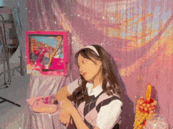 a girl is standing in front of a pink barbie doll box