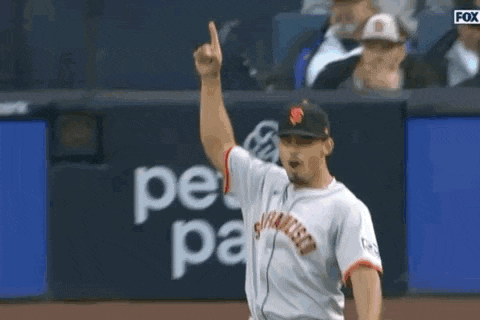 a baseball player is giving a thumbs up sign while standing on a field .