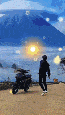 a man stands in front of a motorcycle with a mountain in the background