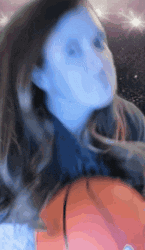 a blurry picture of a woman 's face with a blue background
