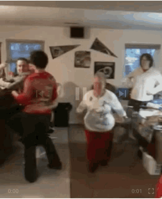 a group of people are dancing in a room and one of them is wearing a shirt that says kc