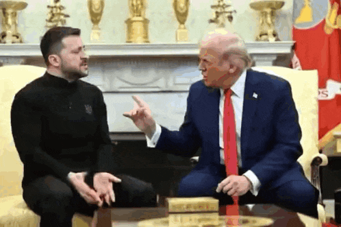 a man in a black shirt is pointing at a man in a suit and tie