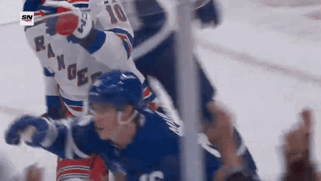 a hockey player with the number 10 on his jersey is being tackled