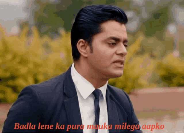 a man in a suit and tie says badla lene ka pura makuka milega aapko