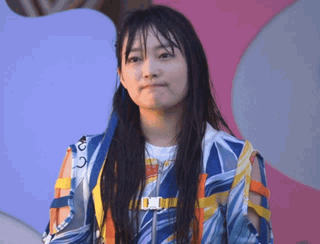 a woman wearing a colorful jacket with a buckle on the front