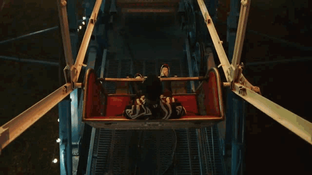 a person is riding a ferris wheel with the letter j on their shirt