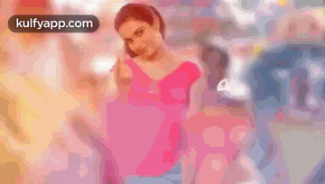 a woman in a pink shirt is standing in front of a sign that says ranga .