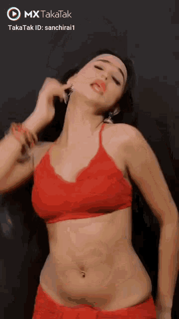 a woman in a red bra and shorts is dancing on a mx takatak video