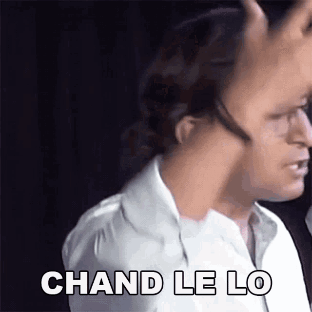 a man in a white shirt is making a funny face and says chand le lo .