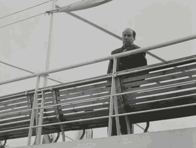 a man waving from a railing on a ship