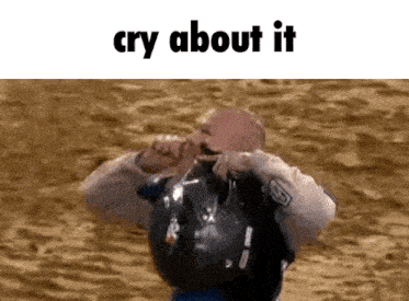 a man wearing a helmet is crying while standing in the sand .