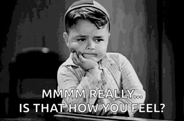 a little boy is sitting at a desk with his hand on his chin and says `` mmmm really ... is that how you feel ? ''