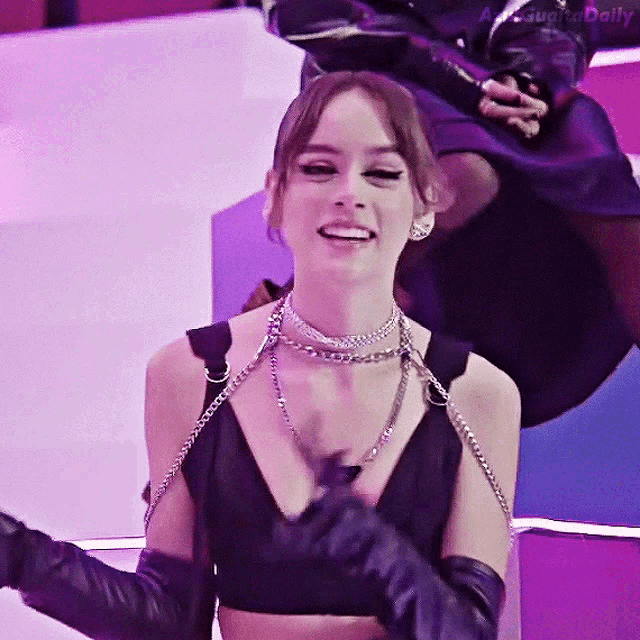 a woman wearing a choker and gloves is smiling in a photo taken by a photographer daily