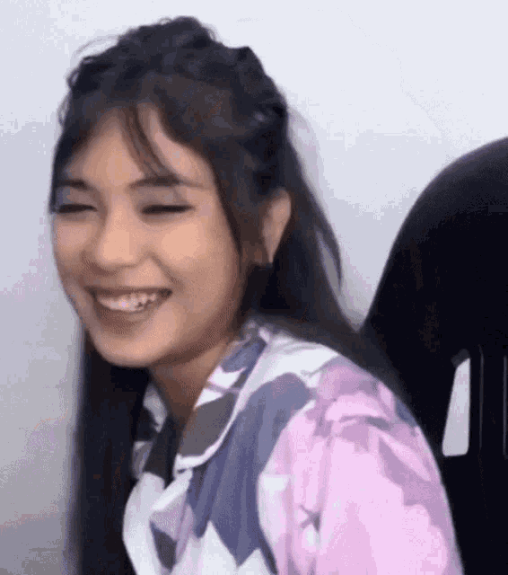 a close up of a woman smiling with her eyes closed .