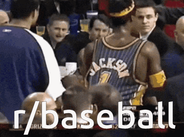 a man in a jackson jersey talks to another man in a crowd