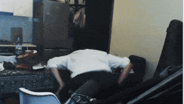 a man in a white shirt is laying on the floor in front of a microphone