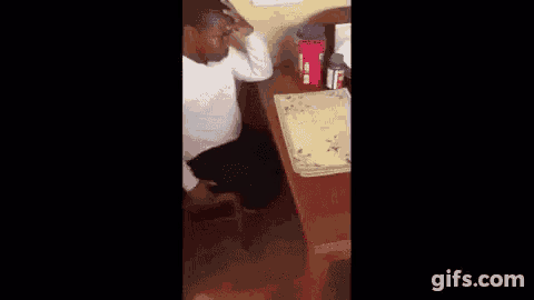 a young boy is sitting at a desk in a room with a red cup on it .