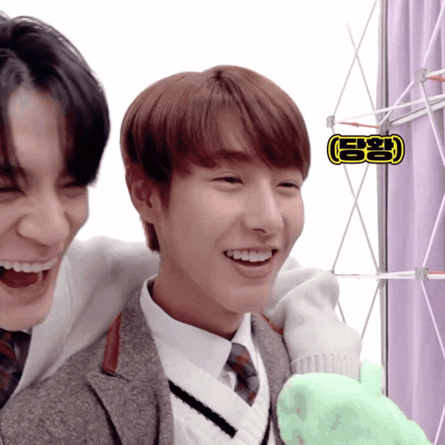 two young men are laughing and one has a sticker on his head that says ' a '
