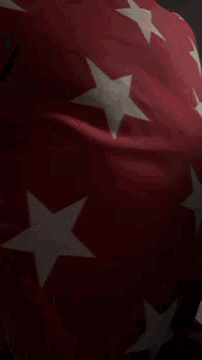 a red flag with white stars on it is waving in the wind