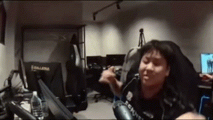 a woman is sitting in a chair in a room with a microphone and a laptop .
