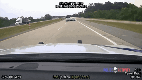 a car driving down a highway with gps 108 mph written on the dashboard