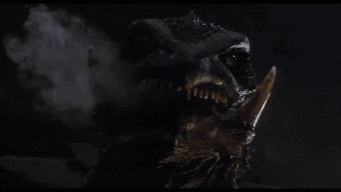 a close up of a monster 's head with smoke coming out of it 's mouth