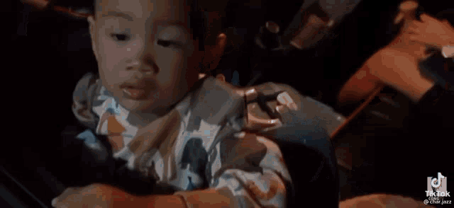 a woman is sitting in the driver 's seat of a car holding a cell phone .