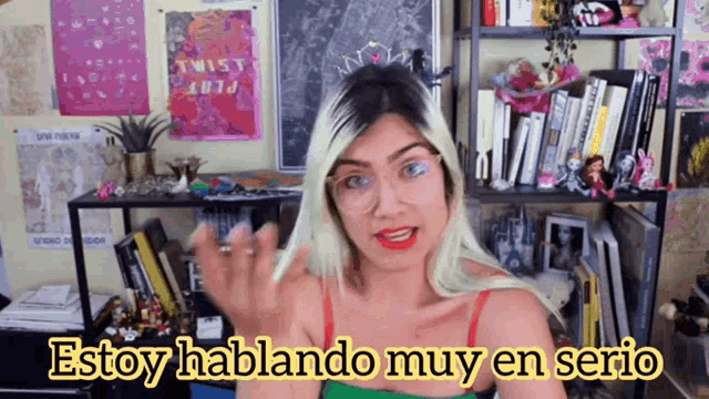a woman wearing glasses says " estoy hablando muy en serio " in yellow letters