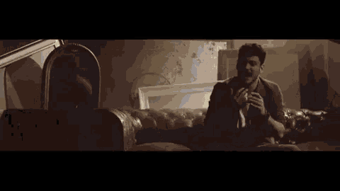 a man with a beard is crying while sitting in a car at night .