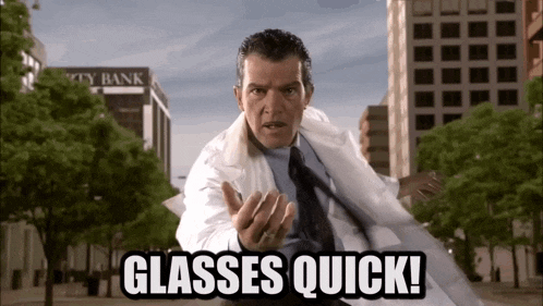 a man in a lab coat says " glasses quick " in front of a city bank