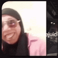 a woman wearing sunglasses and a hijab is smiling for a picture