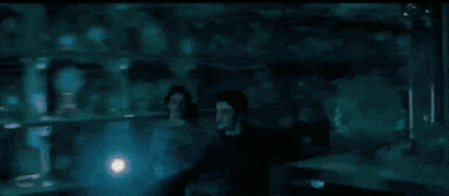 a group of people are standing in a dark room with glowing lights behind them