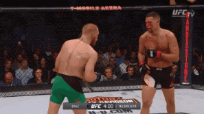 two men are fighting in a ufc ring with a t-mobile arena advertisement in the background