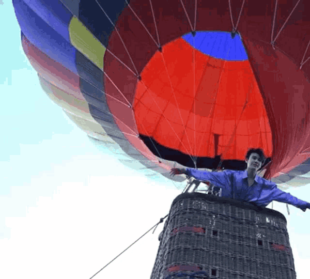 a man in a hot air balloon with a blue shirt on