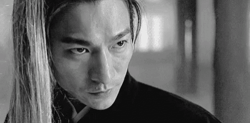 it is a black and white photo of a man with long hair .