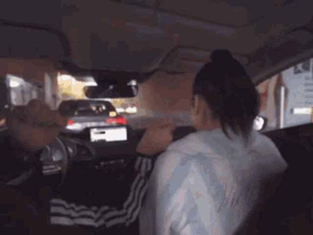 a woman driving a car wearing a sweater that says ' argentina ' on it