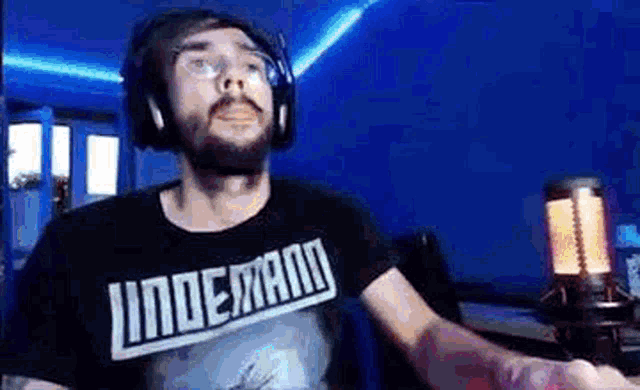 a man with a beard is wearing headphones and a t-shirt that says `` undermann '' .
